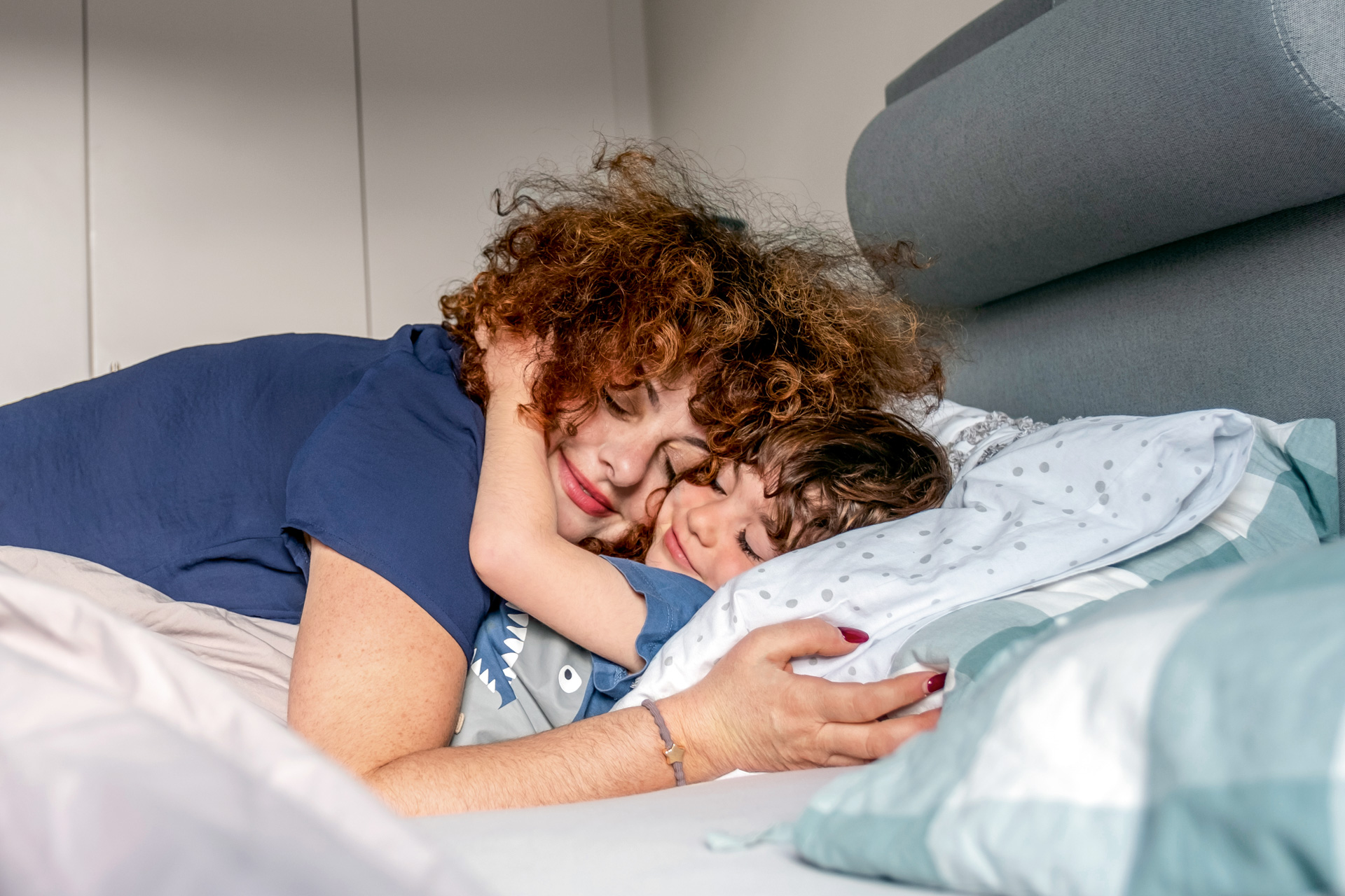 Leende mamma kramar om sitt barn
